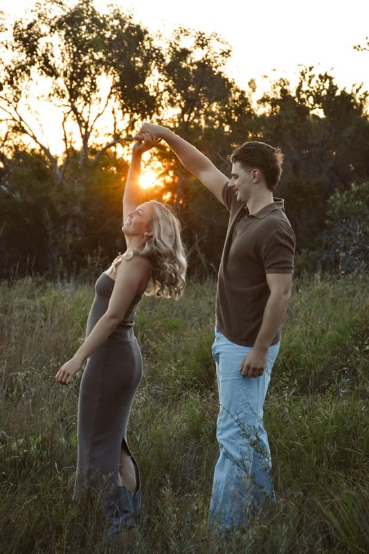 Couple dancing in a paddock at sunrise