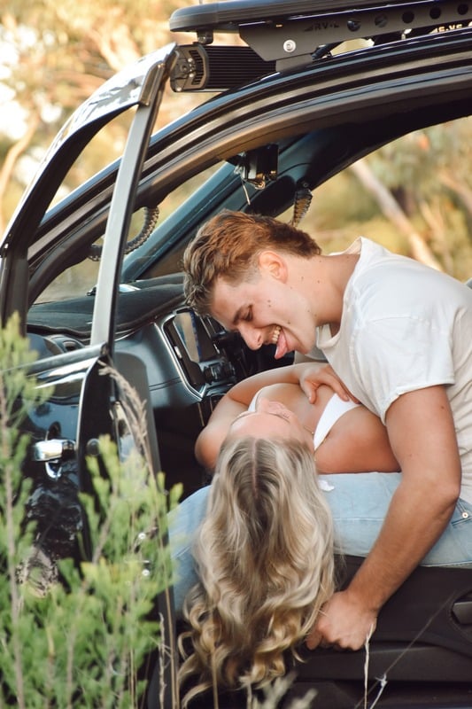 Couple laughing in the boot of a four wheel drive