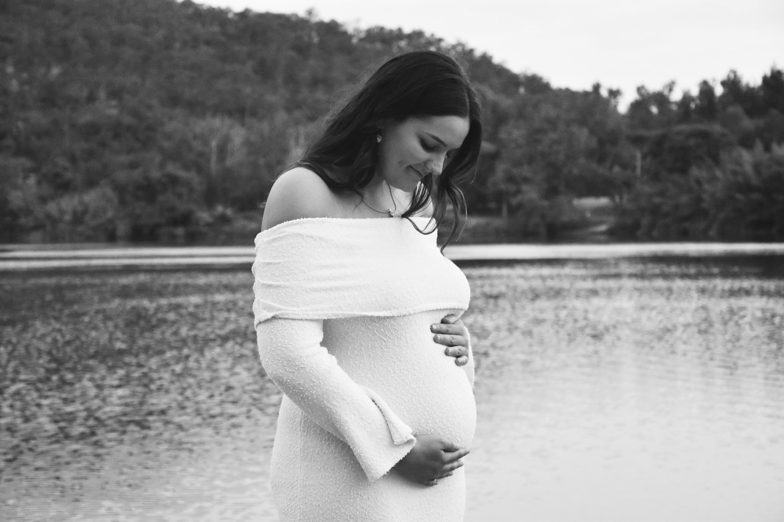 Black and white maternity portrait beside a lake